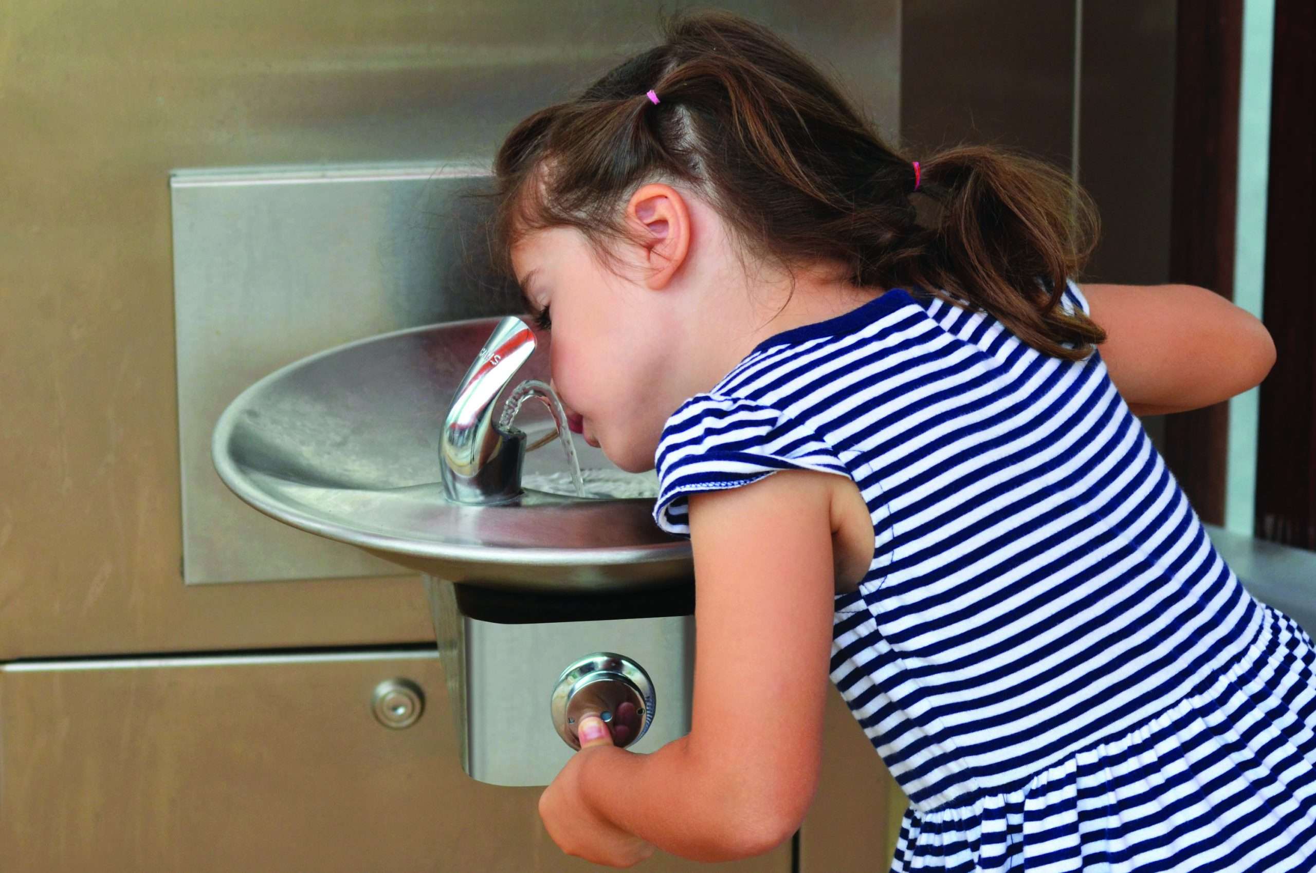 Little girl (age 04) drink water from outdoor water fountain.