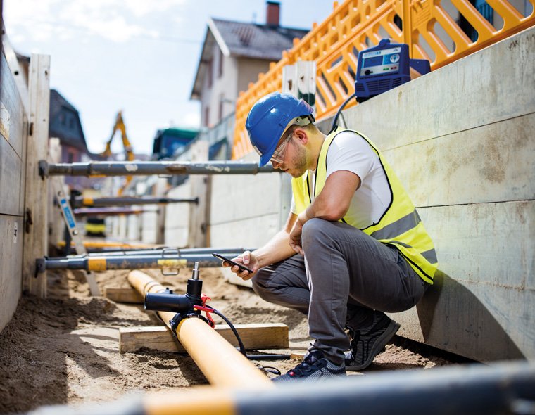 Worker fuses yellow gas pipe with Friamat 6 electrofusion machine